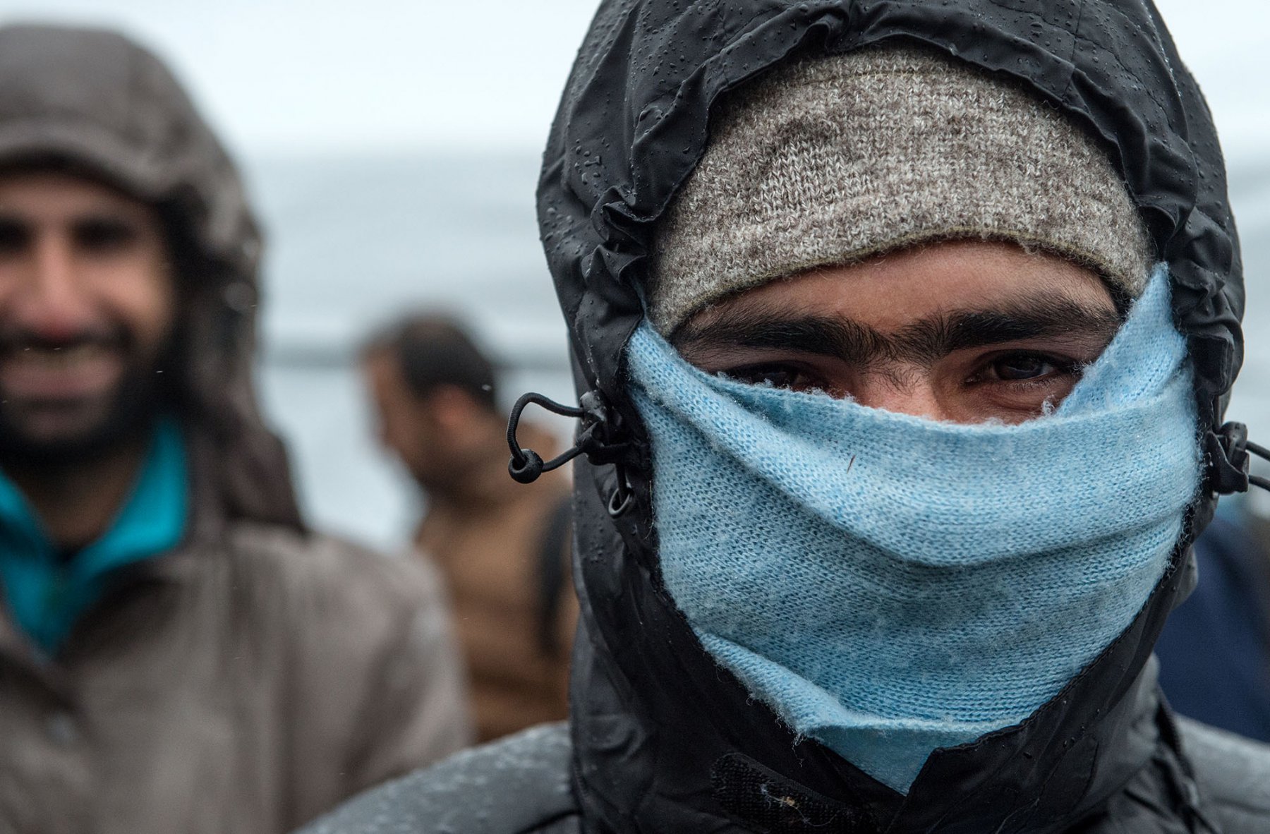 Ein Flüchtling mit Gesichtsschutz steht bei Temperaturen knapp über dem Gefrierpunkt in einem Zeltlager bei Schwarzenborn (Hessen). Foto: Boris Roessler/dpa   