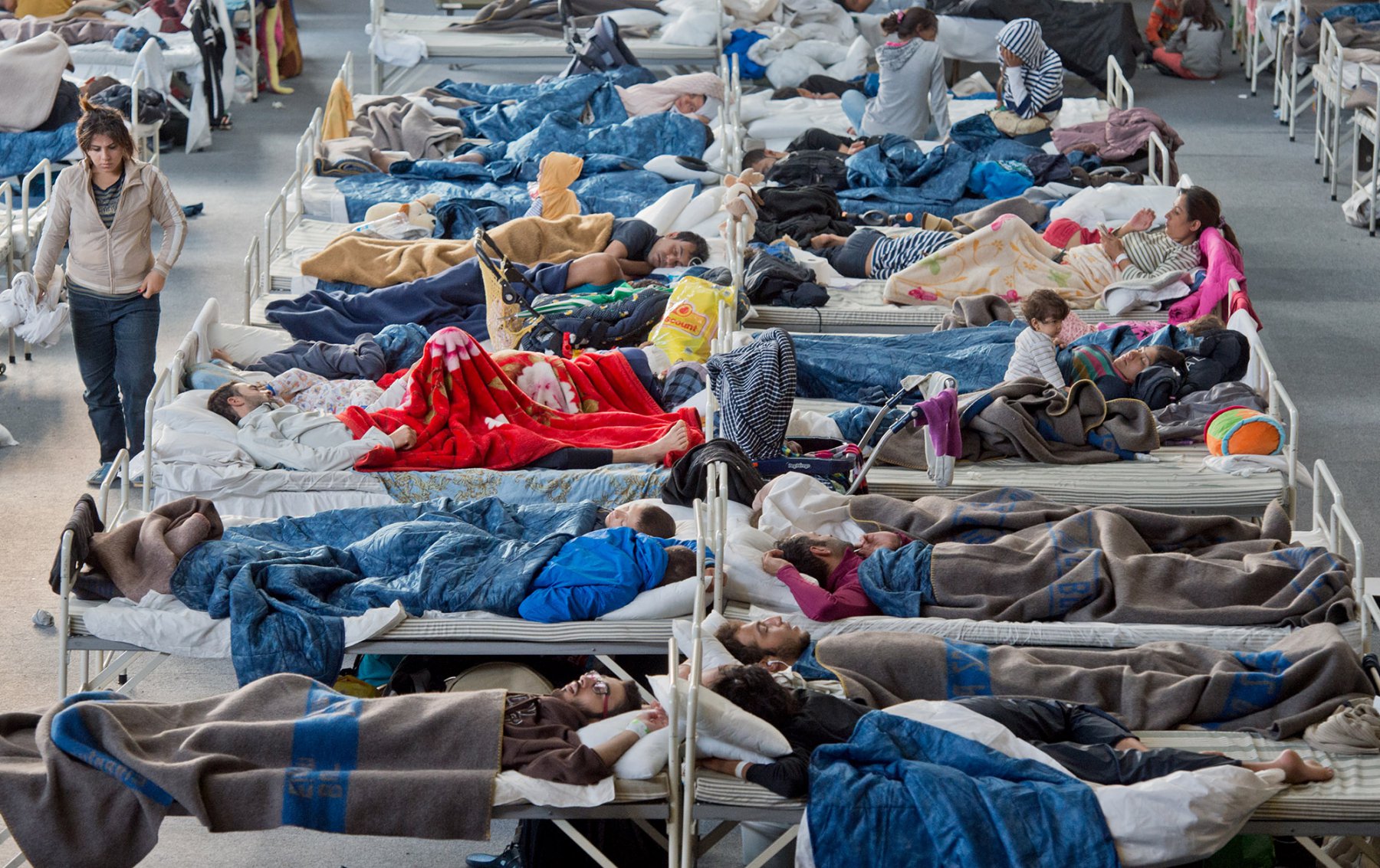 Auf Feldbetten schlafen Flüchtlinge in einer Turnhalle in Hanau (Hessen). Foto: Boris Roessler/dpa 