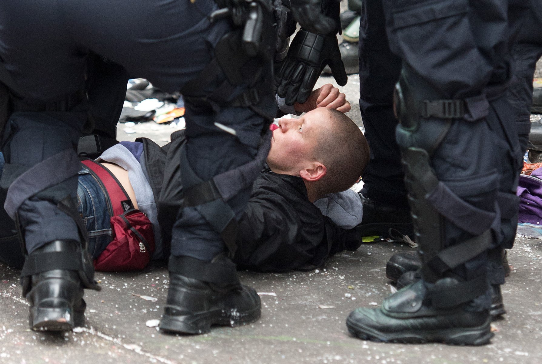 Um eine kollabierte Demonstrantin der Blockupy-Bewegung kümmern sich Polizisten am 01.06.2013 in der Innenstadt von Frankfurt am Main (Hessen) nach der gewaltsamen Auflösung eines Polizeikessels. Die Polizei ist mit einem massiven Kräfteaufgebot vor Ort. Foto: Boris Roessler/dpa
