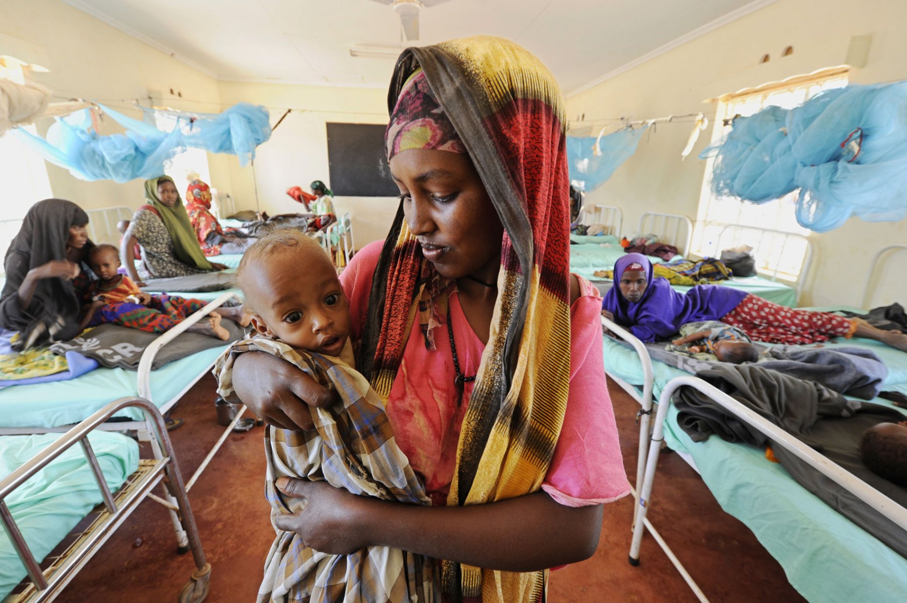 A somalian mother cradles her malnourished baby in a field hospital in a refugee camp in Dadaab, northeastern Kenya on Wednesday, August 3rd 2011. Somalia and parts of Kenya have been struck by one of the worst droughts and famines in six decades, more than 350.000 refugees have found shelter in the worlds biggest refugee camp. Foto: Boris Roessler dpa  +++(c) dpa - Bildfunk+++
