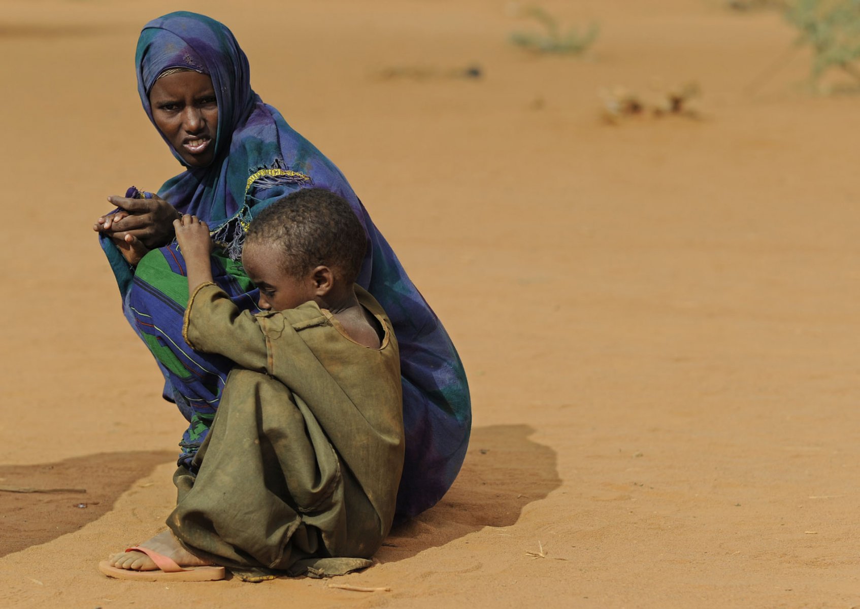 Exhausted after weeks on their feet a Somalian woman and her son are waiting to be granted acess to a refugee camp in Dadaab, northeastern Kenya on wednesday, August 3, 2011. Somalia and parts of Kenya have been struck by one of the worst droughts and famines in six decades, more than 350.000 refugees have found shelter in the worlds biggest refugee camp. Photo: Boris Roessler dpa  +++(c) dpa - Bildfunk+++