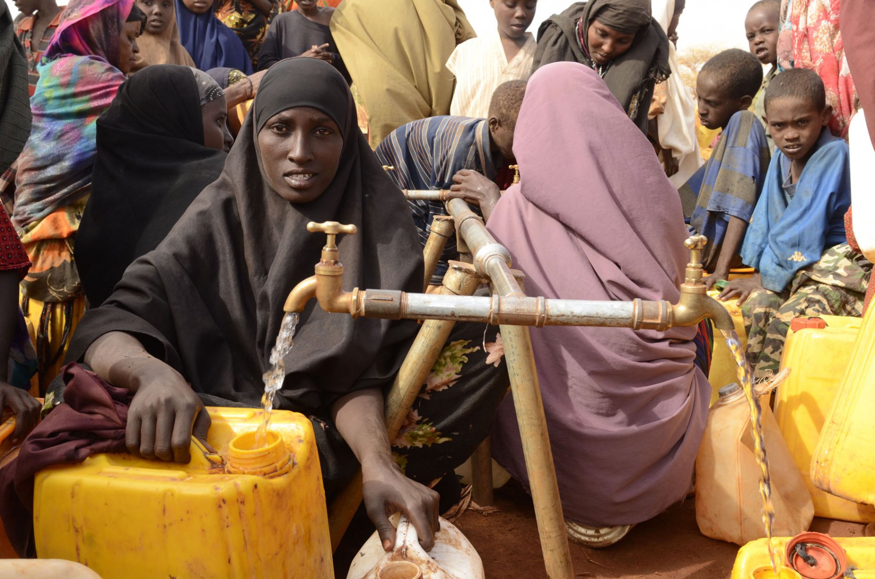 Women filling canisters with drinking water at a refugee camp in Dadaab, northeastern Kenya on thursday, August 4, 2011. Somalia and parts of Kenya have been struck by one of the worst draughts and famines in six decades, more than 350.000 refugees have found shelter in the worlds biggest refugee camp. Photo: Boris Roessler dpa  +++(c) dpa - Bildfunk+++