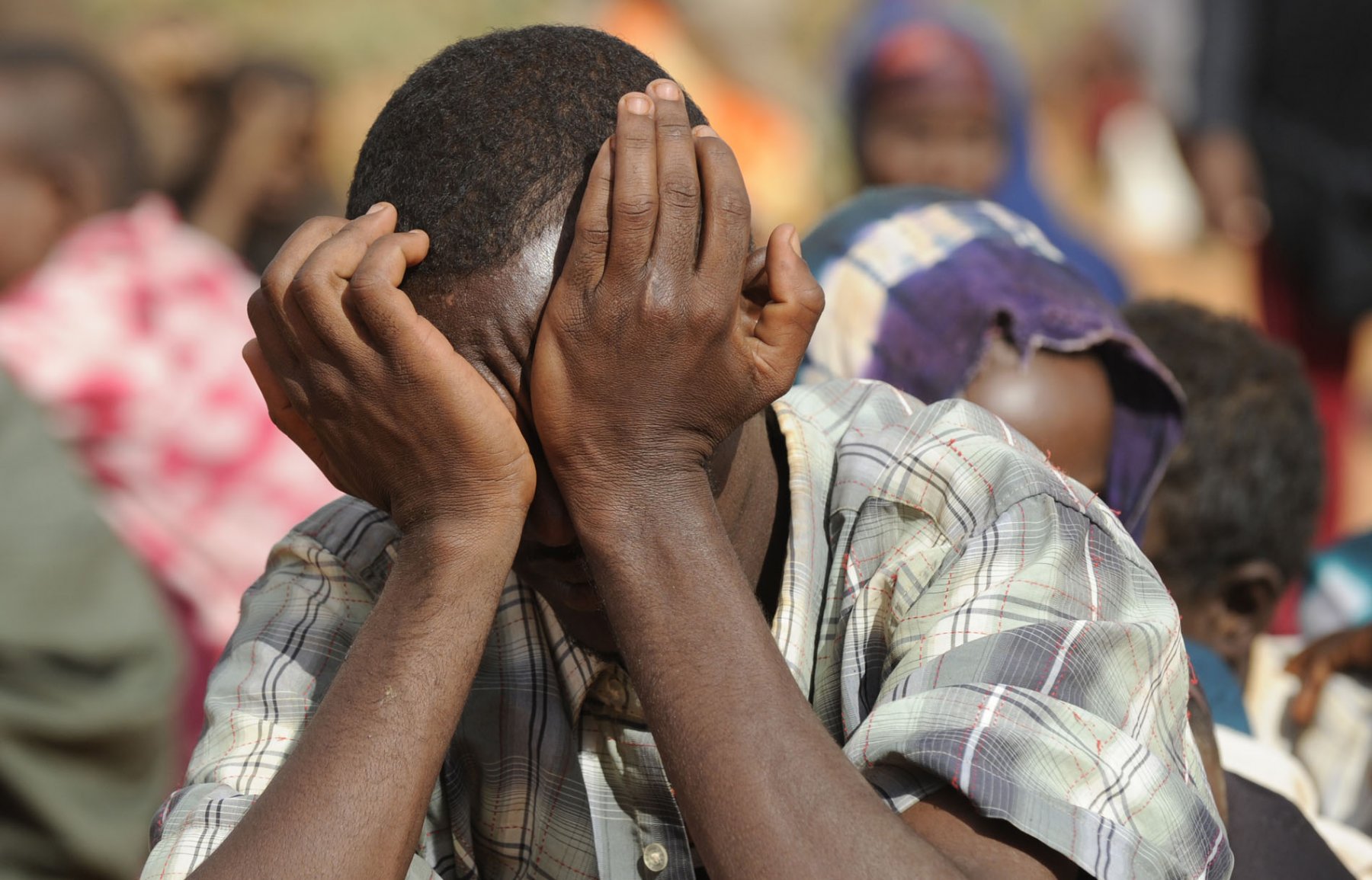 ARCHIV - Ein Mann verbirgt im Flüchtlingscamp Dadaab im Nordosten Kenias am 03.08.2011 sein Gesicht. Der Hungersnot in ihrer Heimat sind die somalischen Flüchtlinge im Lager Dadaab in Kenia entflohen. Doch das Schreckensregime der islamistischen Al-Schabaab-Miliz bekommen sie so leicht nicht aus ihren Köpfen. Fast jeder der ausgezehrten Somalis, die jeden Tag in das größte Flüchtlingscamp der Welt strömen, hat seine Erfahrungen mit der Miliz gemacht. Foto: Boris Roessler dpa (zu dpa 0635 vom 08.08.2011)  +++(c) dpa - Bildfunk+++