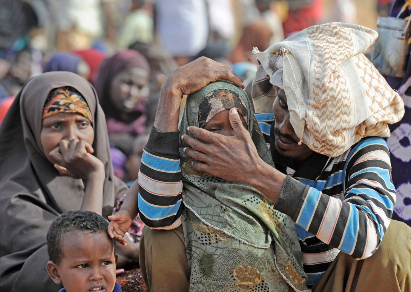 After weeks on the move this somalian refugee tries to calm his little daughter after arriving at a refugee camp in Dadaab, northeastern Kenya on friday, August 5, 2011. Somalia and parts of Kenya have been struck by one of the worst droughts and famines in six decades, more than 350.000 refugees have found shelter in the worlds biggest refugee camp. Foto: Boris Roessler dpa