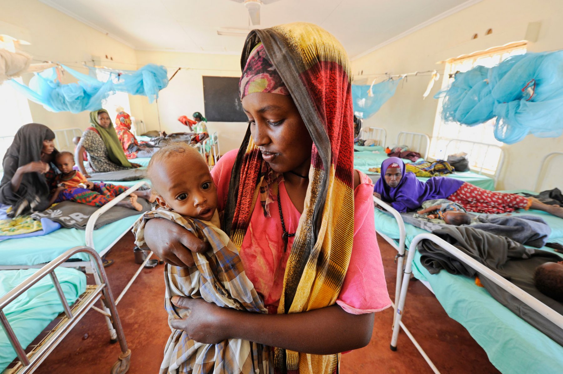 A somalian mother cradles her malnourished baby in a field hospital in a refugee camp in Dadaab, northeastern Kenya on wednesday, August 3rd 2011. Somalia and parts of Kenya have been struck by one of the worst droughts and famines in six decades, more than 350.000 refugees have found shelter in the worlds biggest refugee camp. Foto: Boris Roessler dpa
