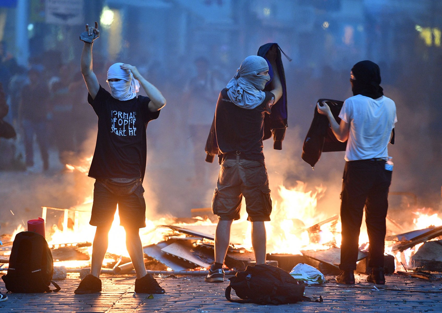 Aktivisten stehen bei Protesten gegen den G-20-Gipfel im Schanzenviertel in Hamburg vor einer brennenden Barrikade. 