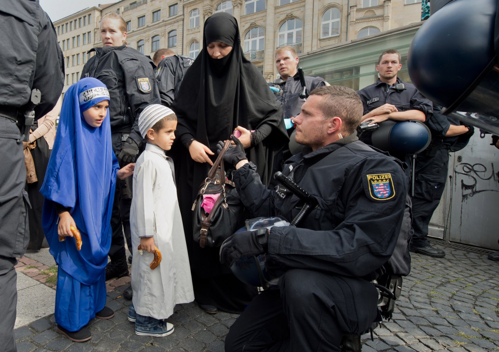 Anhänger des radikal-islamischen Predigers Pierre Vogel nehmen am 07.09.2013 an einer Demonstration in der Innenstadt von Frankfurt am Main (Hessen) teil. Dabei werden die Teilnehmer von Polizisten durchsucht. Die offiziell als "Islamischer Friedenskongress" angemeldete Kundgebung wird von einem massiven Polizeiaufgebot begleitet, mehrere Gegendemonstrationen sind angemeldet. Foto: Boris Roessler/dpa +++(c) dpa - Bildfunk+++