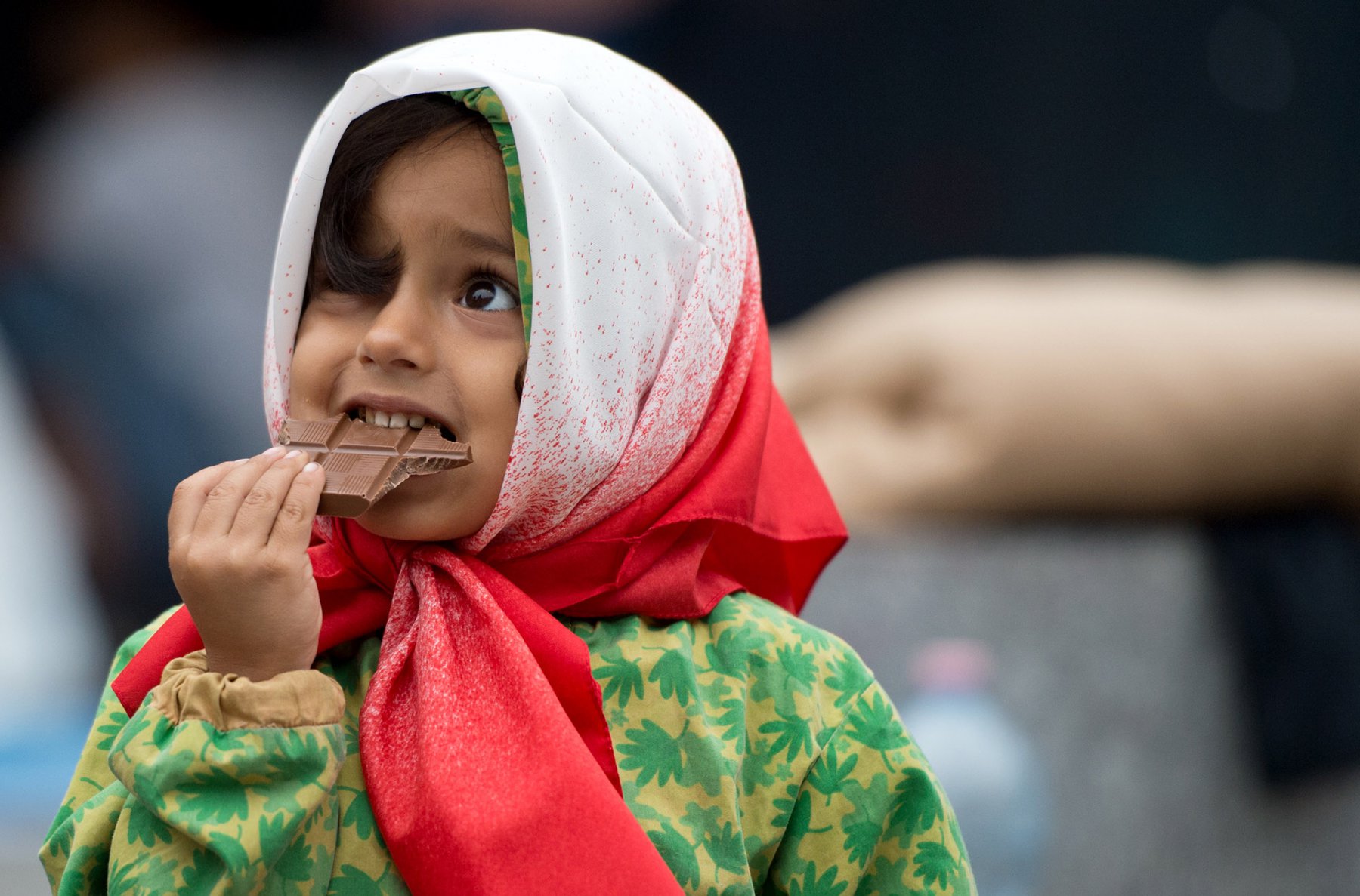 Flüchtlinge warten am 05.09.2015 am Ostbahnhof in Budapest, Ungarn, auf ihre Weiterfahrt nach Westen. Dabei isst ein kleines Mädchen ein Stück gespendete Schokolade. Foto: Boris Roessler/dpa