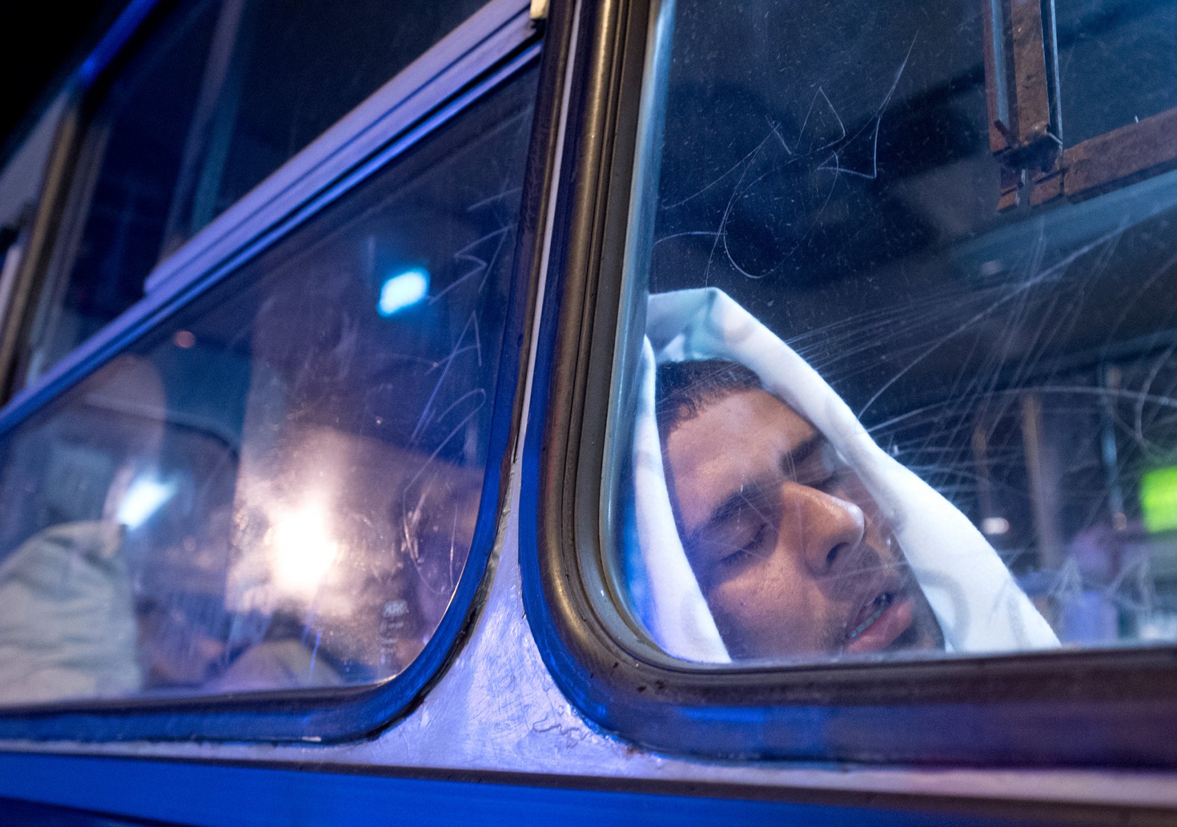 Mitten in der Nacht erreicht tausende Flüchtlinge im am 5. September 2015 vor dem Keleti-Bahmhof in Budapest die Nachricht, dass Sie nach Wochen der Ungewissheit Ungarn verlassen dürfen. Im Bus schlafen manche sofort ein. Foto: Boris Roessler/dpa