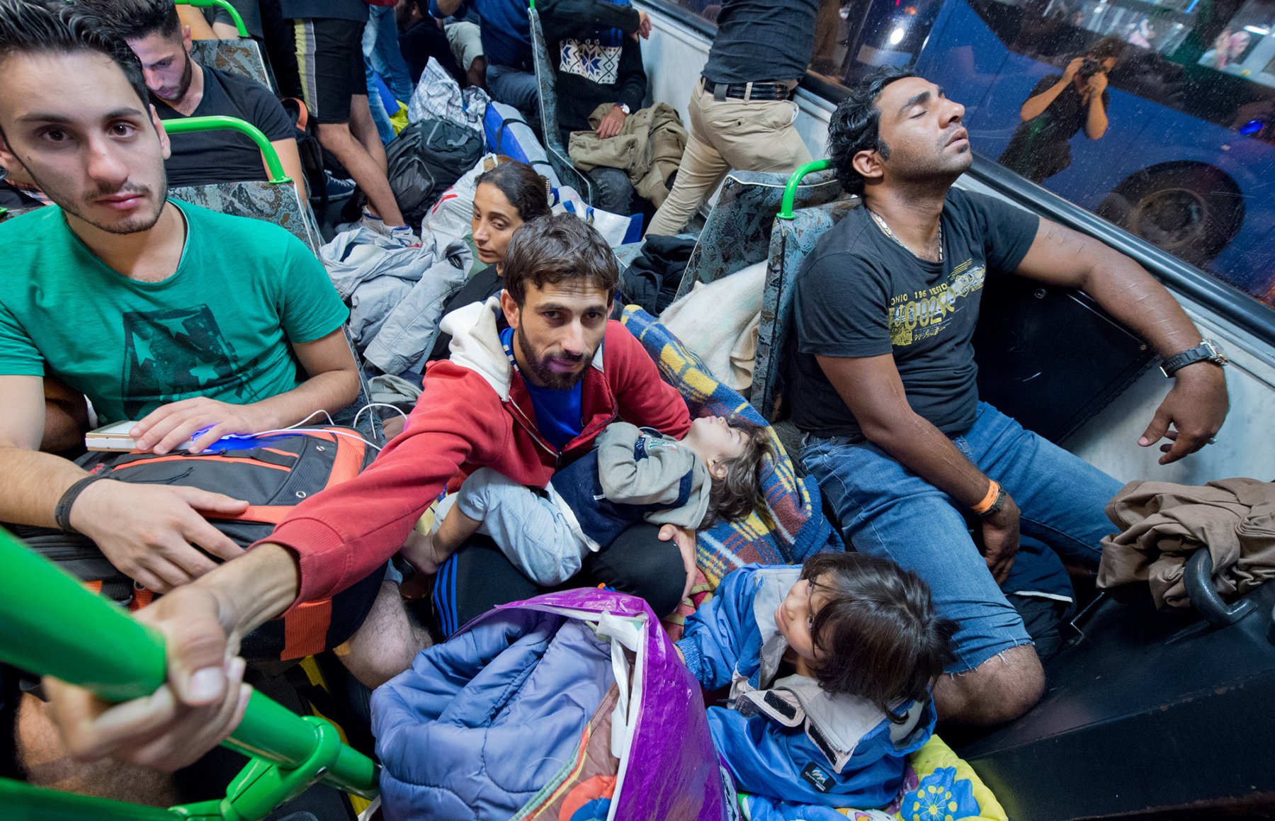 Mitten in der Nacht erreicht tausende Flüchtlinge im am 5. September 2015 vor dem Keleti-Bahmhof in Budapest die Nachricht, dass Sie nach Wochen der Ungewissheit Ungarn verlassen dürfen. Die Busse sind völlig überfüllt. Foto: Boris Roessler/dpa