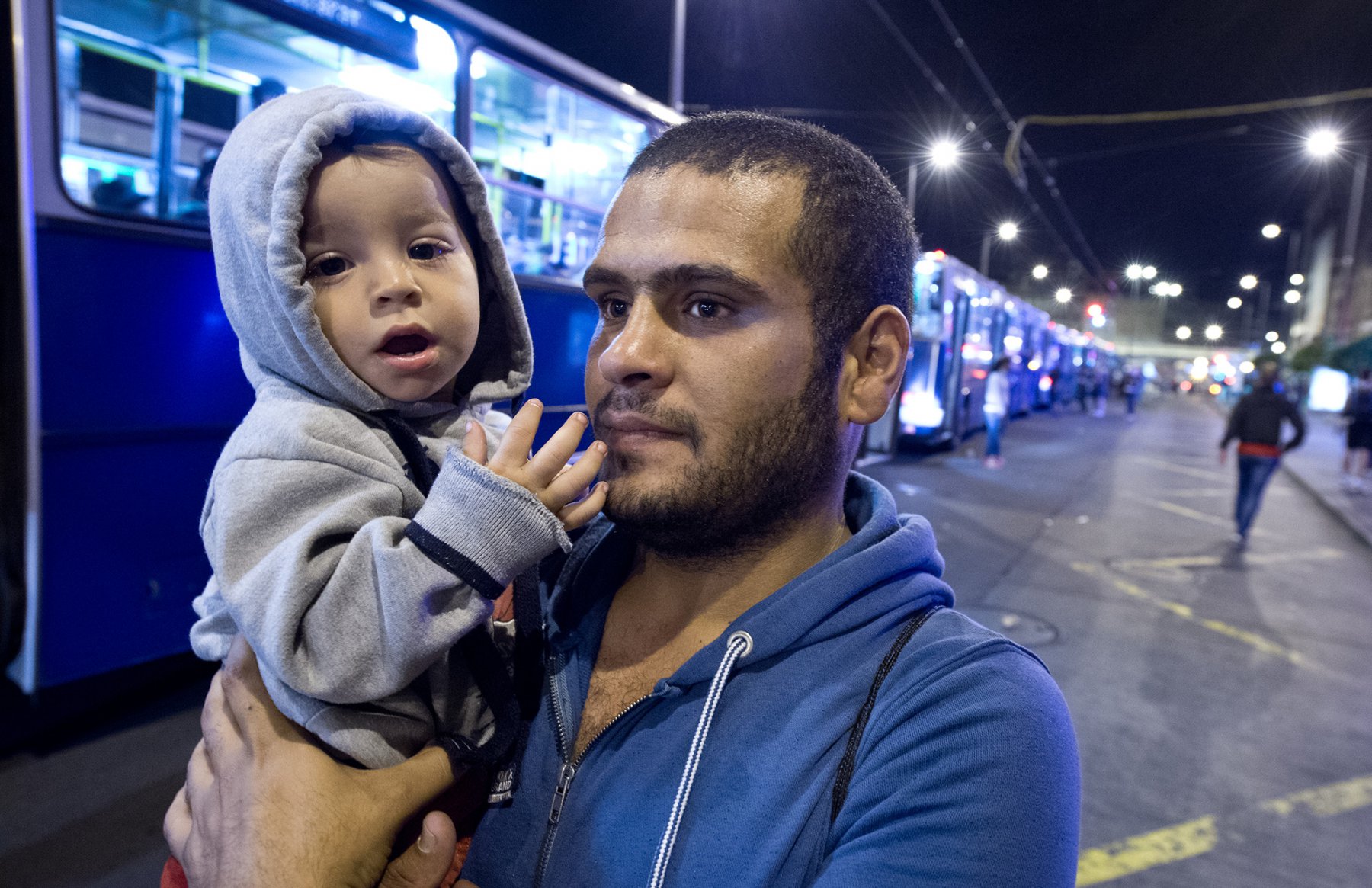 Mitten in der Nacht erreicht tausende Flüchtlinge im am 5. September 2015 vor dem Keleti-Bahmhof in Budapest die Nachricht, dass Sie nach Wochen der Ungewissheit Ungarn verlassen dürfen. Mit seinem Kind im Arm sucht ein Vater nach der Mutter. Foto: Boris Roessler/dpa