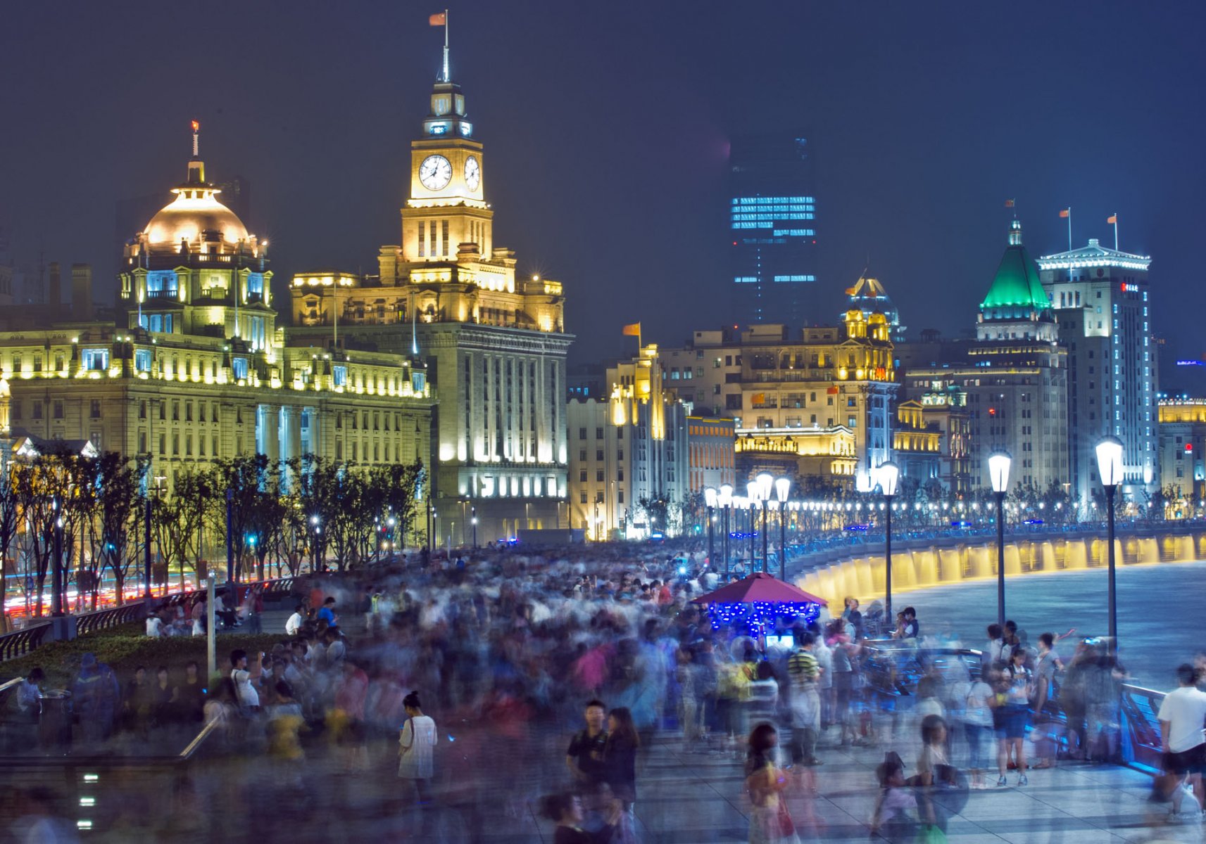 Zehntausende Menschen strömen in den späten Abendstunden über die Uferpromenade "The Bund". Das Flanieren am Wasser bringt dabei vor allem in den heissen Sommermonaten willkommene Abkühlung. Foto: Boris Roessler