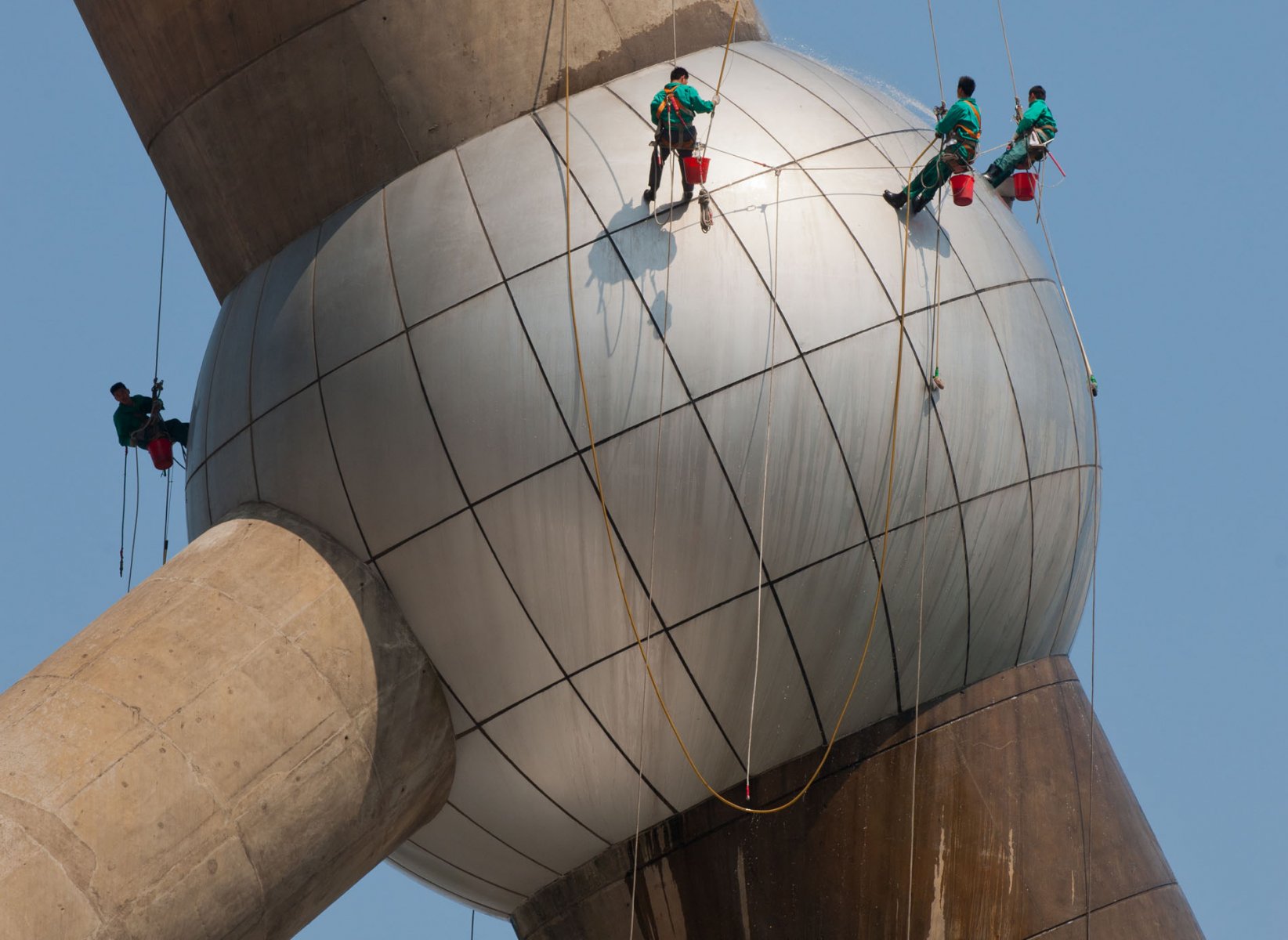 Gesichert durch lange Seile reinigen Kletterer eine der riesigen Kugeln des Oriental Pearl Tower. Foto: Boris Roessler