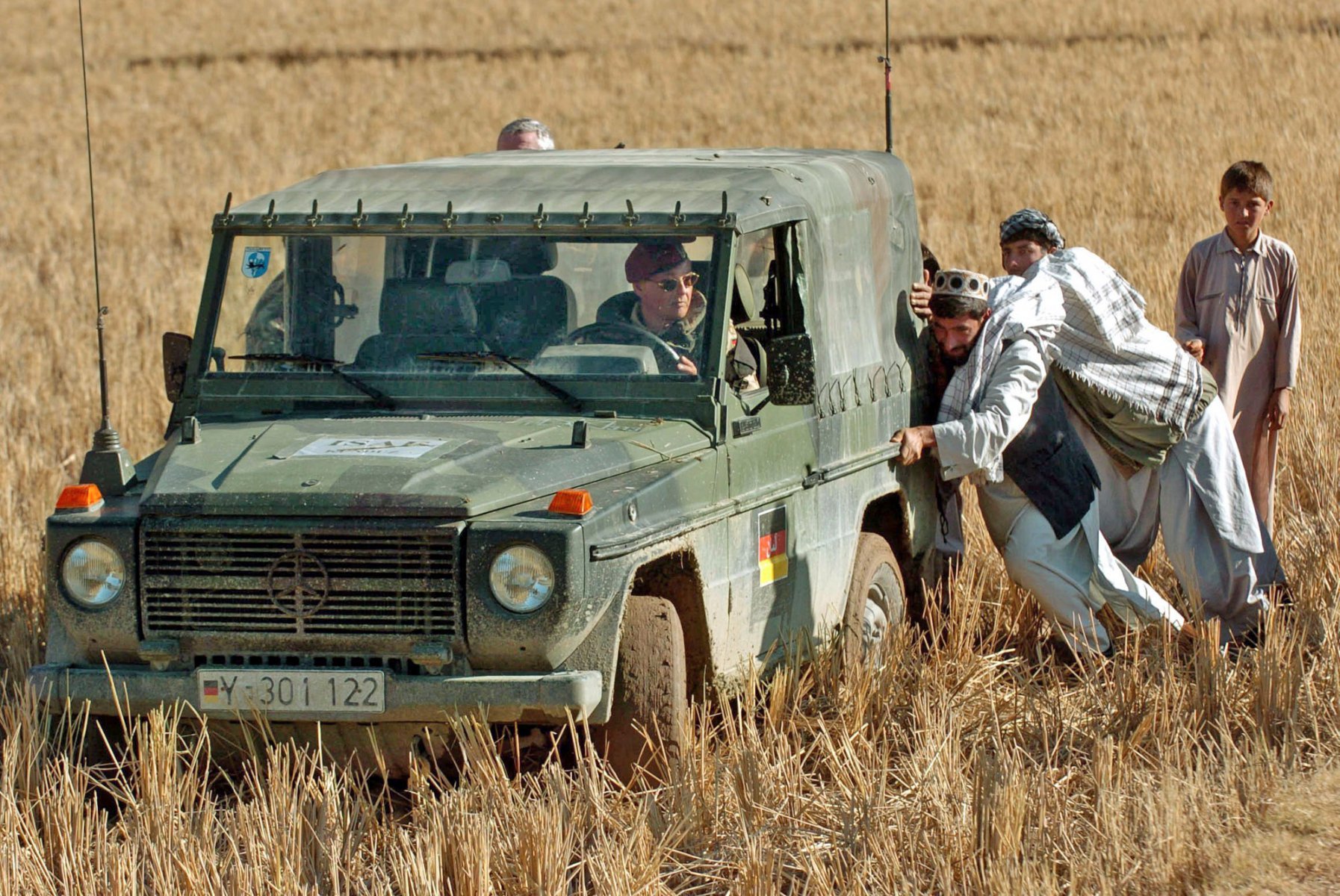 Afghan people help the German federal armed forces to free a deadlocked Wolf military jeep in the Afghan province of Takar, about 40 km southeast of Kundus. Photo: Boris Roessler/dpa