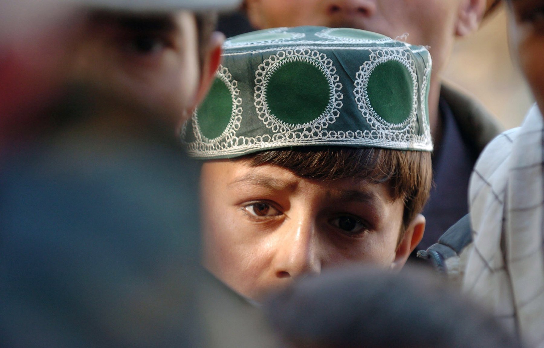 An Afghan boy watches a German armed forces jeep in Kundus, Afghanistan. Kundus is one of four Afghan provinces guarded by the German federal armed forces. Photo: Boris Roessler/dpa