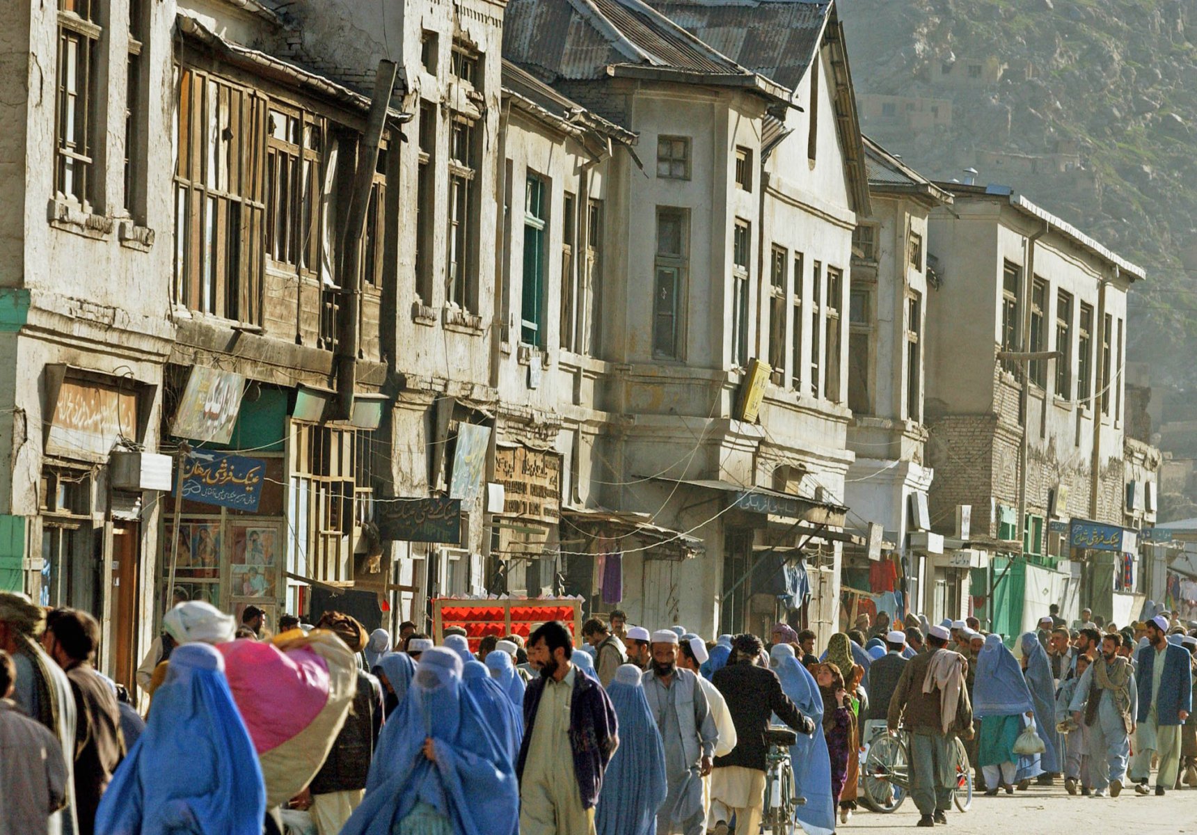 Menschenmassen drängen sich an Häusern im britischen Viertel der afghanischen Haupstadt Kabul vorbei. Die im Kolonialstil errichteten Häuser sind zum größten Teil baufällig. Foto: Boris Roessler/dpa