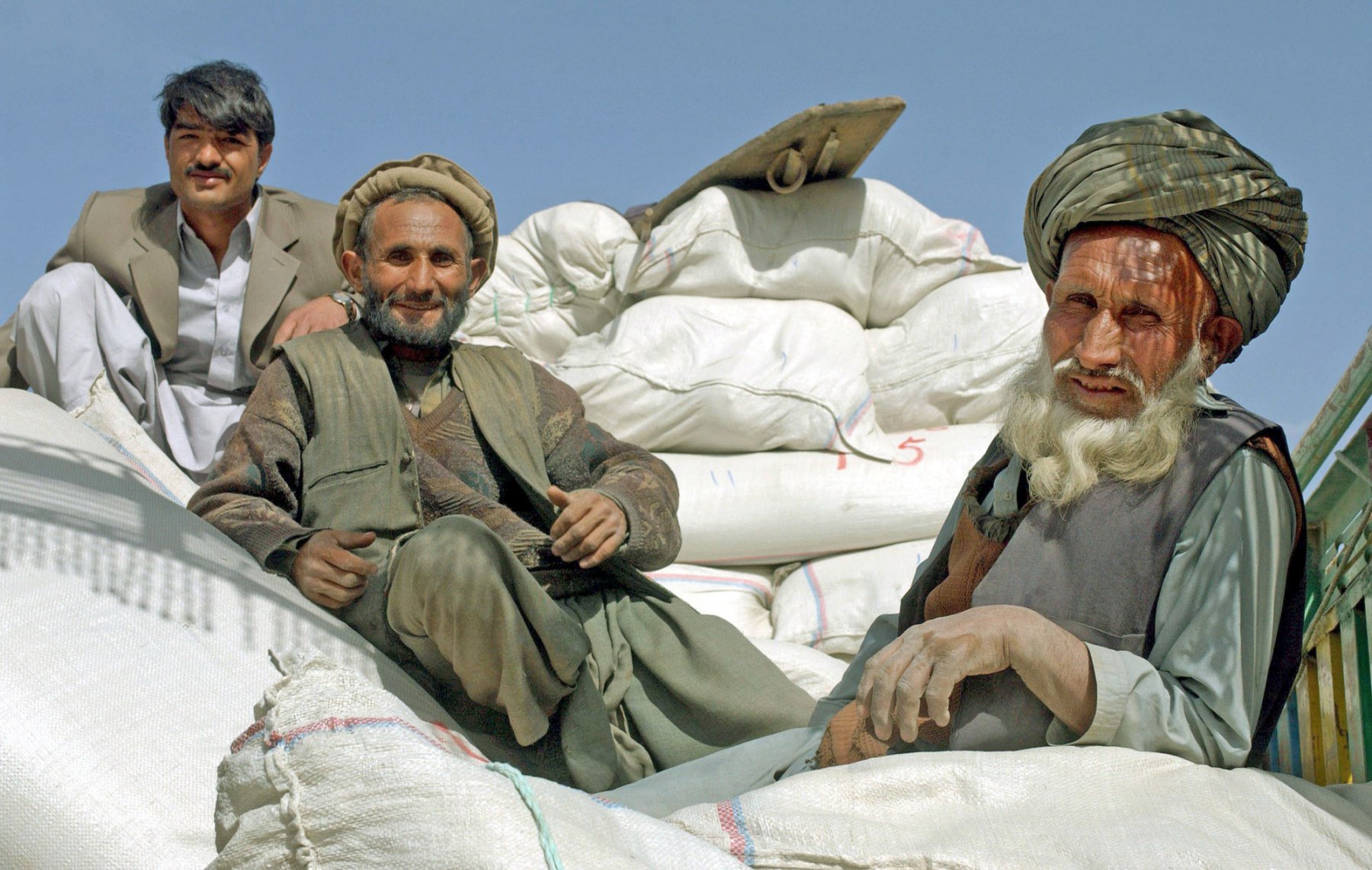 Eine Pause machen drei Arbeiter, die auf einem Basar bei Kabul Weizensaat für den Export in eine nördliche Provinz verladen. Die stärksten Regenfälle seit fünf Jahren lassen die afghanischen Bauern auf eine gute Ernte hoffen. Foto: Boris Roessler/dpa