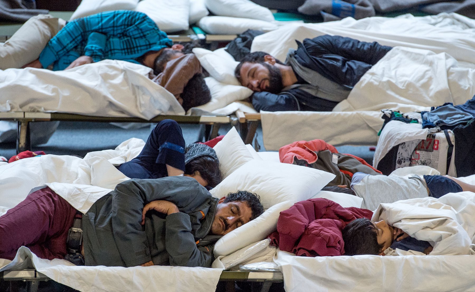 Auf Feldbetten schlafen Flüchtlinge in einer Turnhalle in Hanau (Hessen). Foto: Boris Roessler/dpa   