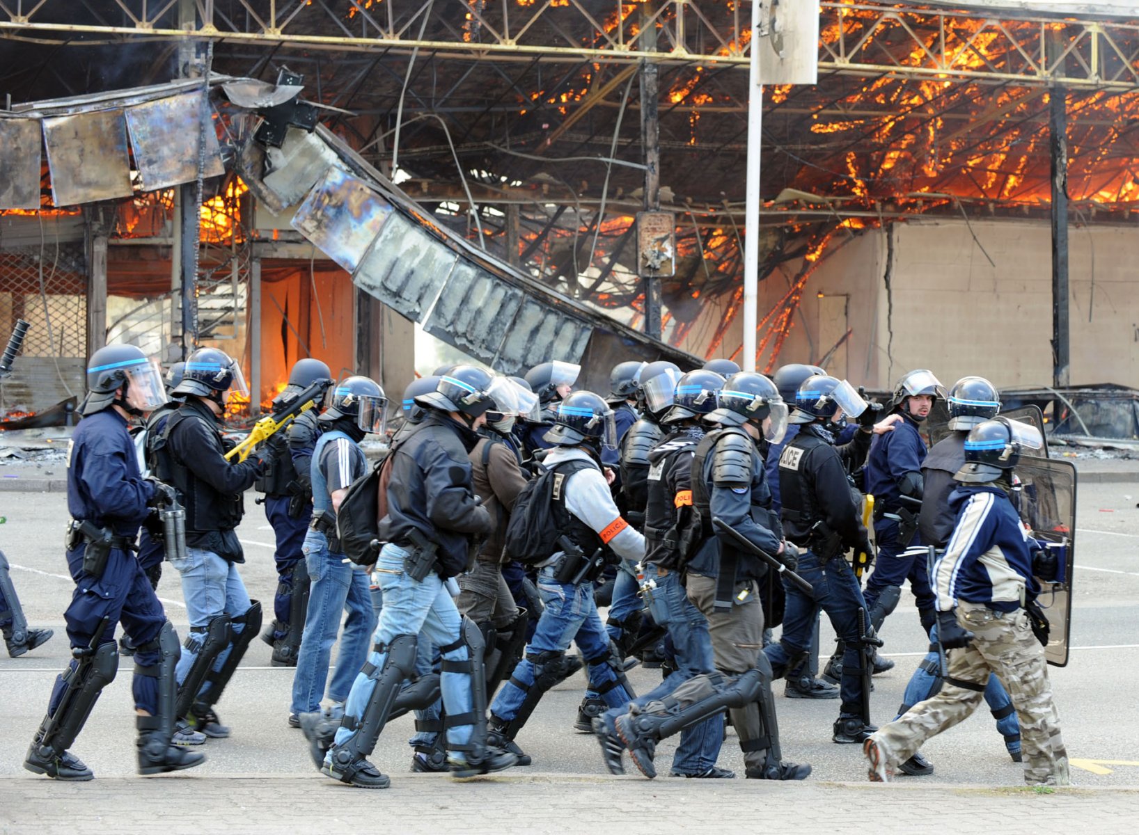 Spezialeinheiten vor einem brennenden Supermarkt in Straßburg, nachdem dieser am Samstag (04.04.2009) von Autonomen in Brand gesteckt wurde. Militante NATO-Gegner haben Brandsätze in ein Hotel und mehrere andere Gebäude geworfen. In dem Hotel brach Feuer aus. Foto: Boris Roessler dpa +++(c) dpa - Bildfunk+++