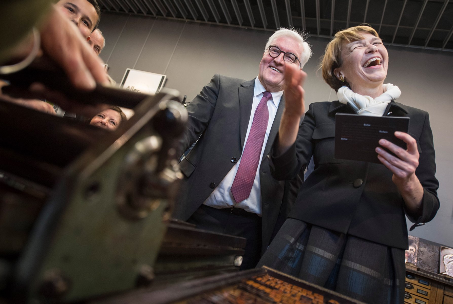 Bundespräsident Frank-Walter Steinmeier und seine Frau Elke Büdenbender lassen sich bei ihrem Besuch in Mainz die Funktion einer kleinen Druckpresse erklären. 