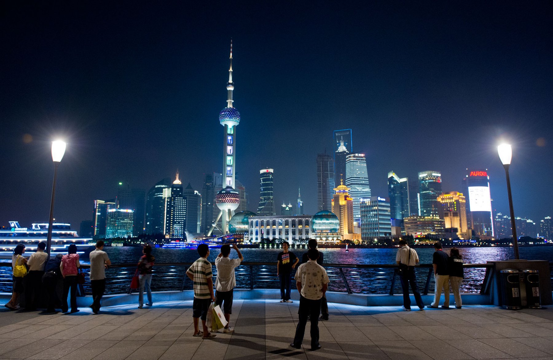 Touristen und Einheimische flanieren über die Uferpromenade "The Bund" in Shanghai und geniessen dabei den Blick auf den Financial District der Millionenmetropole. Foto: Boris Roessler