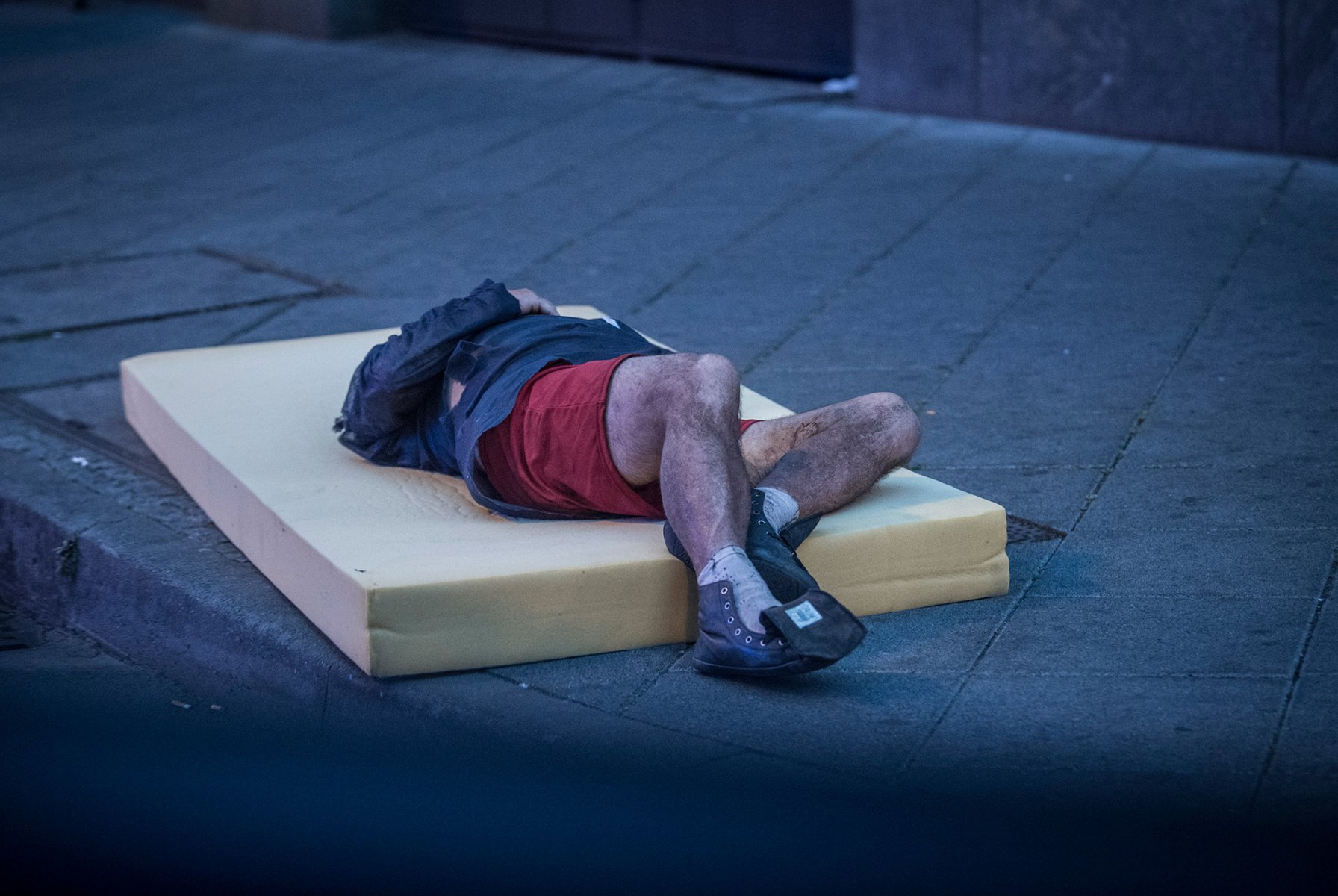 Frankfurt, Bahnhofsviertel, August 2018: Ein Junkie schläft seinen Rausch auf einer alten Matratze am Straßenrand aus. Foto: Boris Roessler/dpa