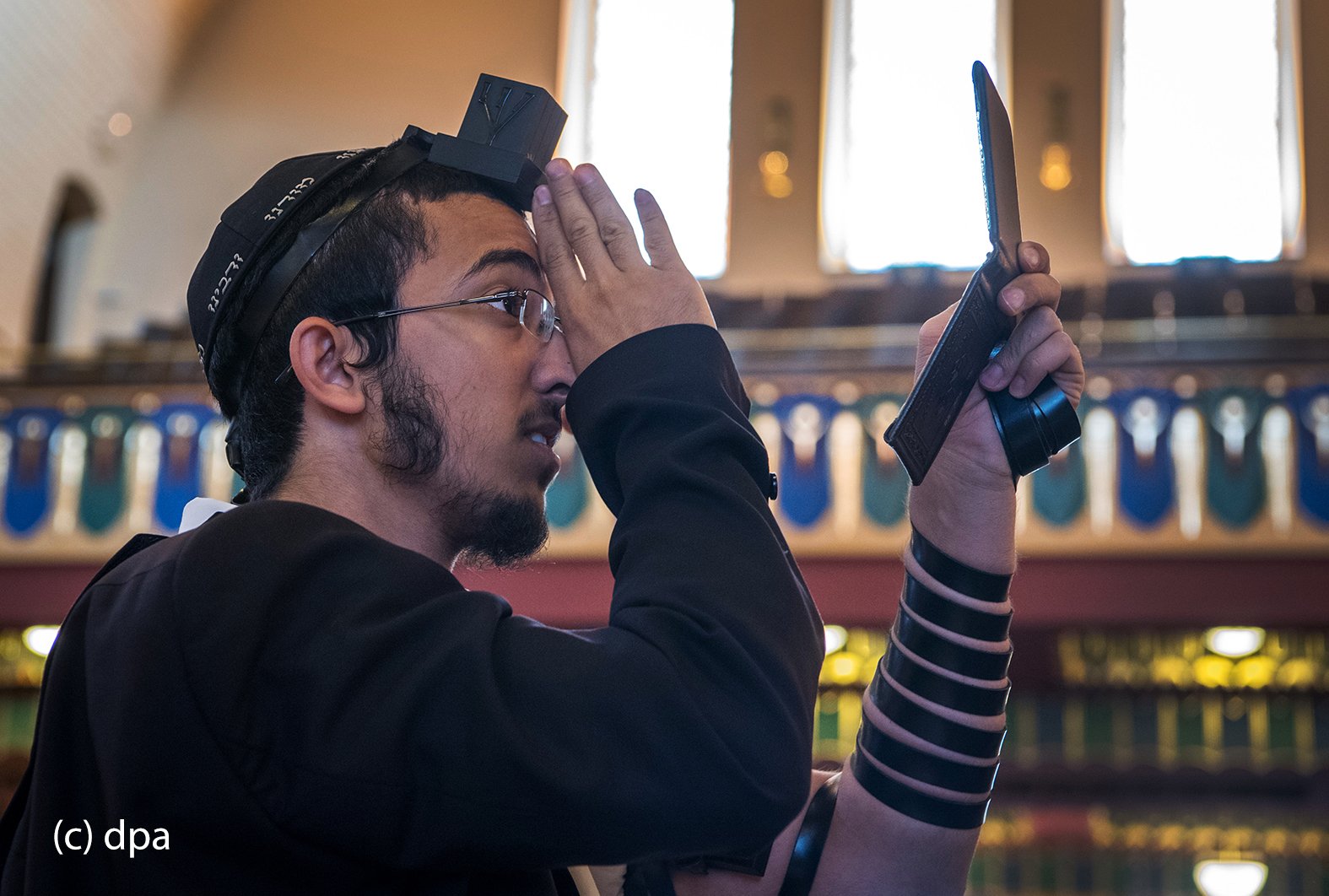 Den korrekten Sitz seines Gebetsriemens kontrolliert ein gläubiger Jude in der Westend-Synagoge in Frankfurt am Main mit Hilfe eines Spiegels. 